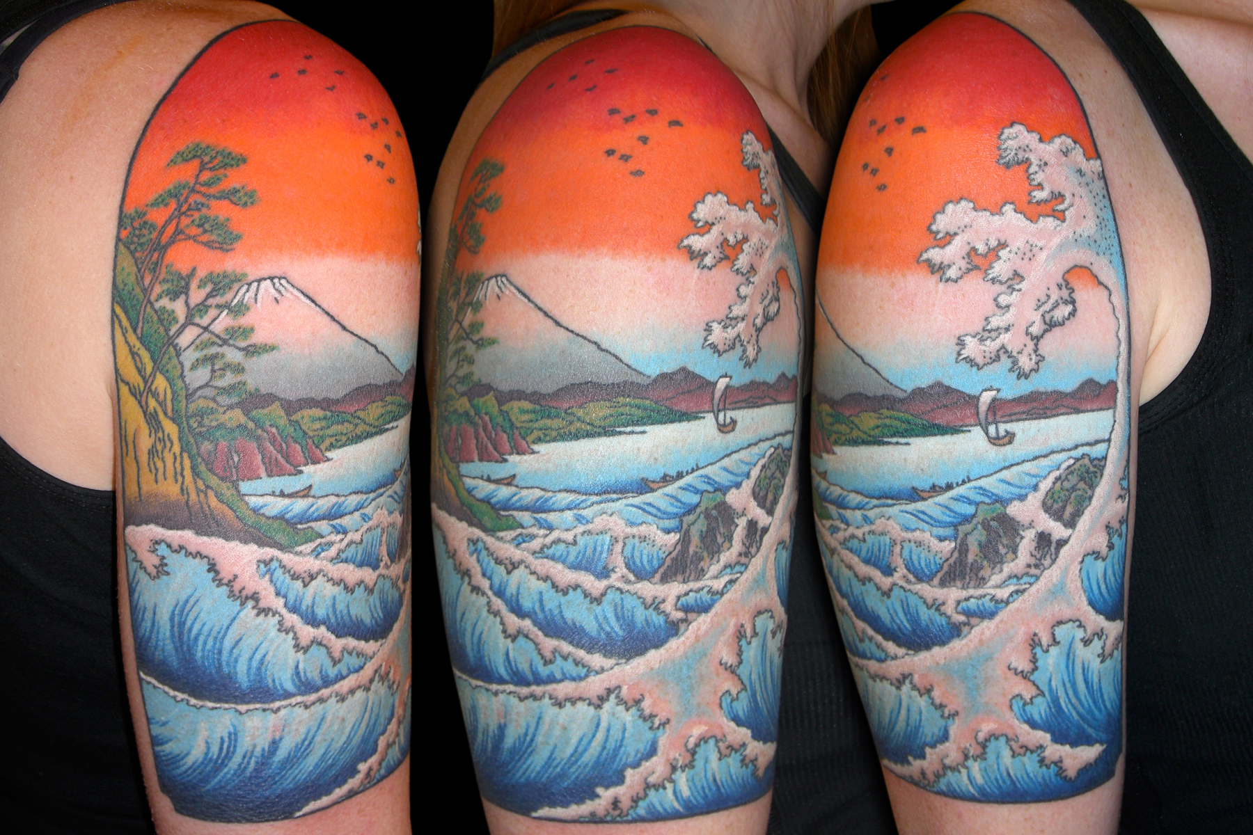 Colorful upper arm tattoos in Japanese print style with Mt. Fuji and crashing waves