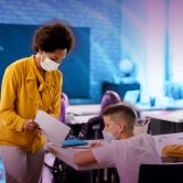 Teacher looking at assignment with two students